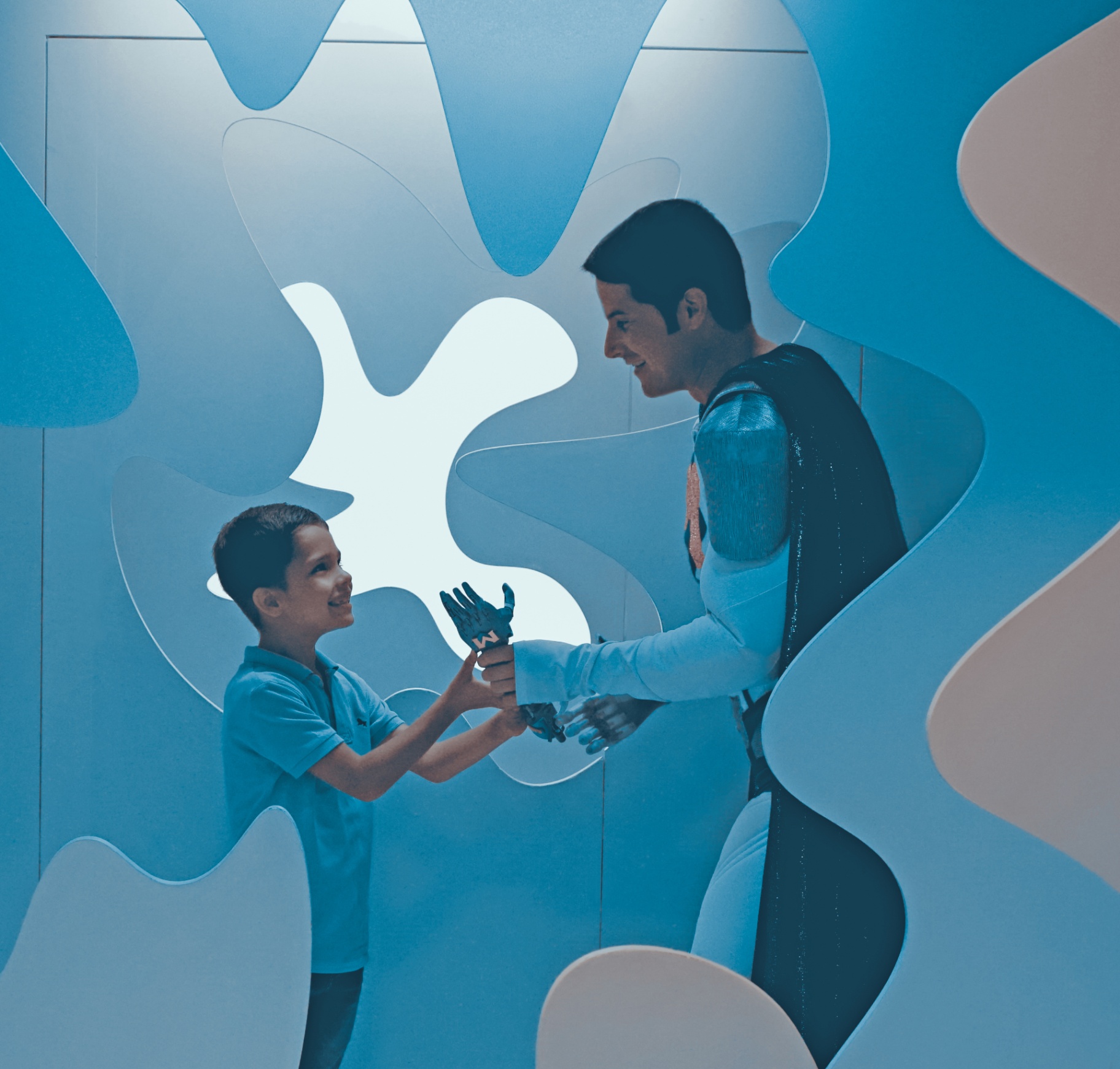 Bionicman übergibt einem Kind eine 3D-gedruckte Handprothese von Give Children a Hand.
